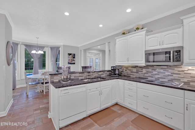 kitchen featuring decorative light fixtures, kitchen peninsula, white dishwasher, sink, and tasteful backsplash