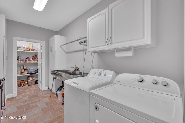 laundry room with cabinets, sink, separate washer and dryer, and light tile floors