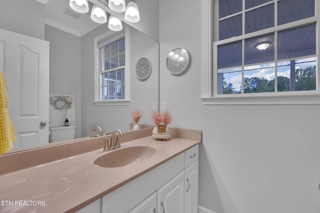 bathroom with plenty of natural light, toilet, oversized vanity, and crown molding