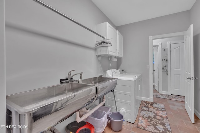 laundry area with cabinets, light tile floors, and washing machine and clothes dryer