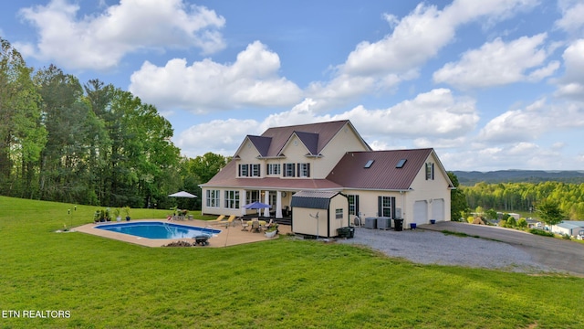 rear view of property featuring a patio area, a yard, an outdoor structure, and a garage