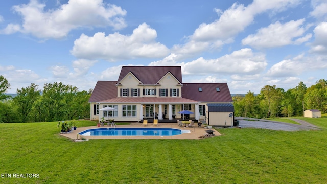 back of house with a yard, a patio, and a storage unit