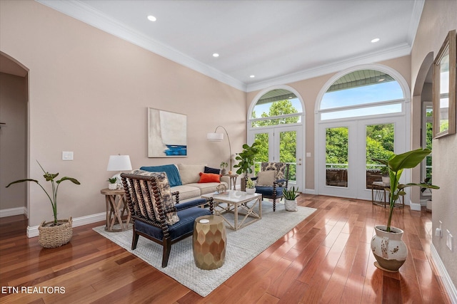 living room featuring hardwood / wood-style floors, crown molding, and french doors