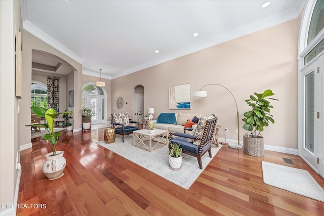 living room with hardwood / wood-style flooring and crown molding