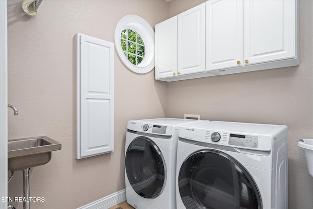 washroom featuring cabinets, separate washer and dryer, and sink