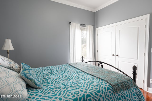 bedroom featuring a closet, wood-type flooring, and crown molding