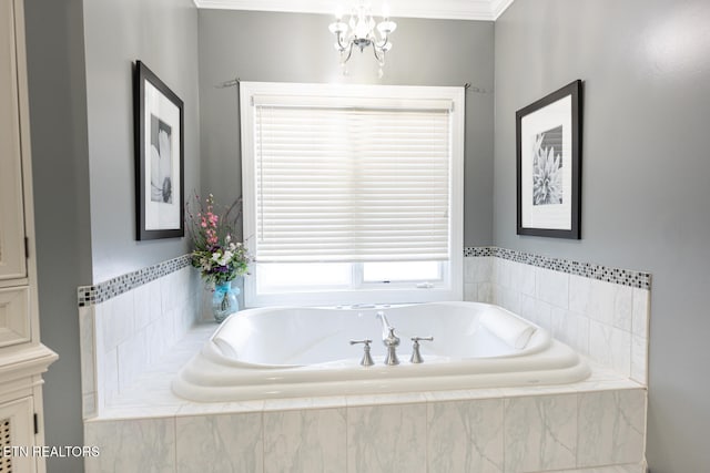 bathroom with ornamental molding, a notable chandelier, and tiled bath