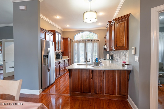 kitchen featuring kitchen peninsula, hardwood / wood-style floors, crown molding, stainless steel refrigerator with ice dispenser, and sink