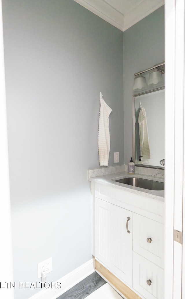 bathroom featuring vanity, ornamental molding, and hardwood / wood-style flooring