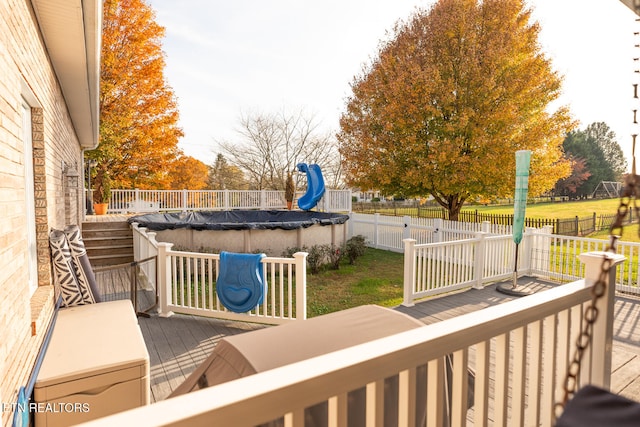 wooden deck with a yard and a covered pool