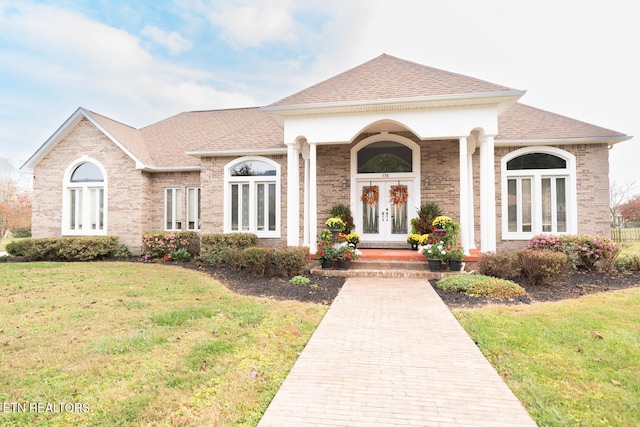 view of front of home with french doors and a front yard