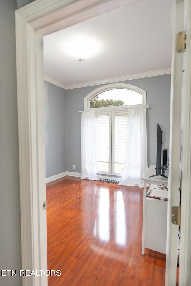 unfurnished room featuring ornamental molding and hardwood / wood-style flooring