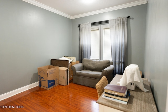 sitting room with crown molding and hardwood / wood-style flooring