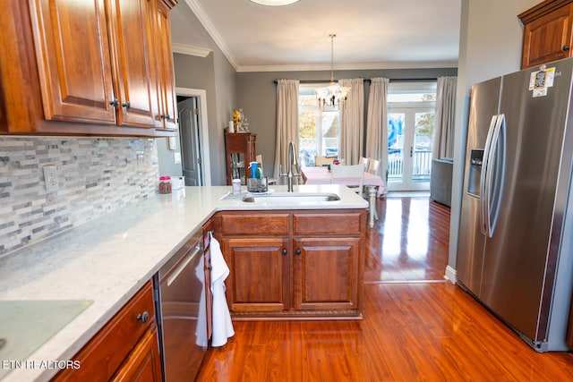 kitchen with dark hardwood / wood-style floors, stainless steel appliances, sink, and decorative light fixtures