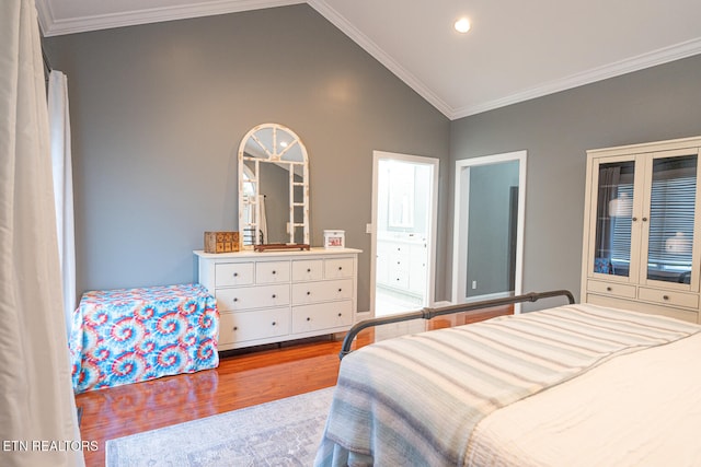 bedroom with hardwood / wood-style floors, crown molding, vaulted ceiling, and ensuite bath