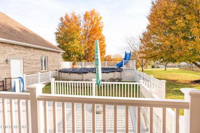 wooden deck with a yard and a covered pool