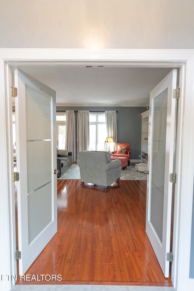 unfurnished living room with hardwood / wood-style floors and french doors