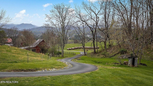 exterior space featuring a mountain view and a lawn