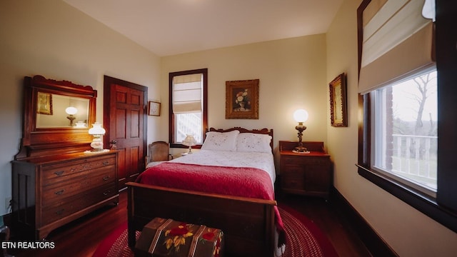 bedroom with dark wood-type flooring and multiple windows