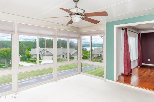 unfurnished sunroom featuring a ceiling fan