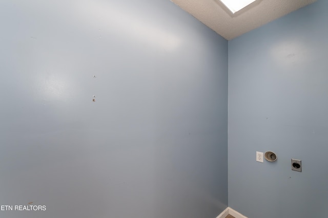 laundry room featuring laundry area, a textured ceiling, baseboards, and electric dryer hookup