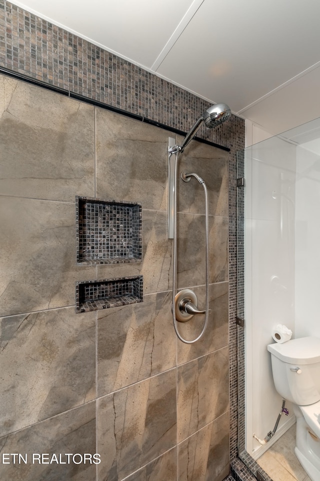 bathroom with toilet and tiled shower