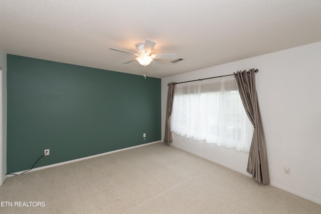 unfurnished room featuring a ceiling fan, a textured ceiling, and baseboards