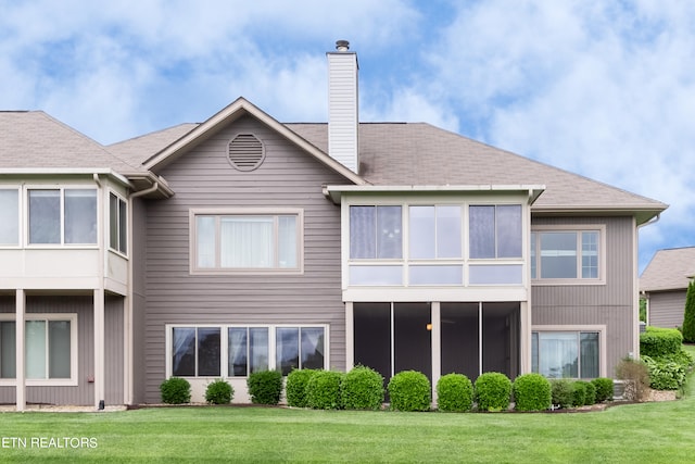 back of house with a lawn and a sunroom