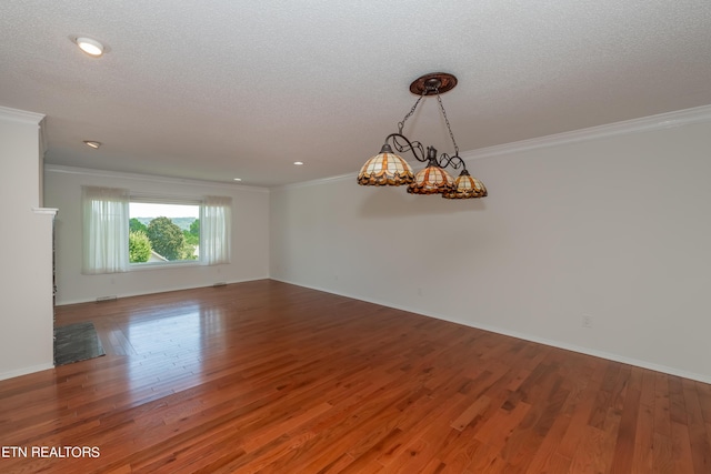 unfurnished room featuring crown molding, a textured ceiling, baseboards, and wood finished floors