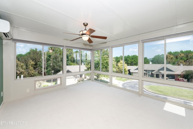 unfurnished sunroom featuring ceiling fan, an AC wall unit, and plenty of natural light