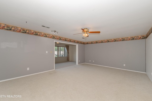 empty room with a ceiling fan, light carpet, visible vents, and baseboards