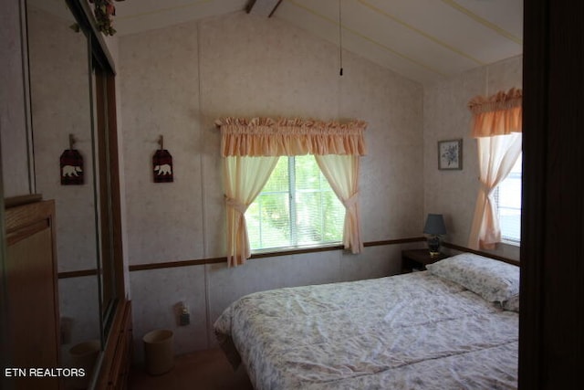 bedroom with vaulted ceiling with beams