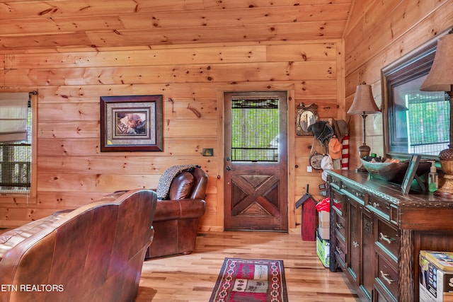 interior space with wood walls and light hardwood / wood-style floors