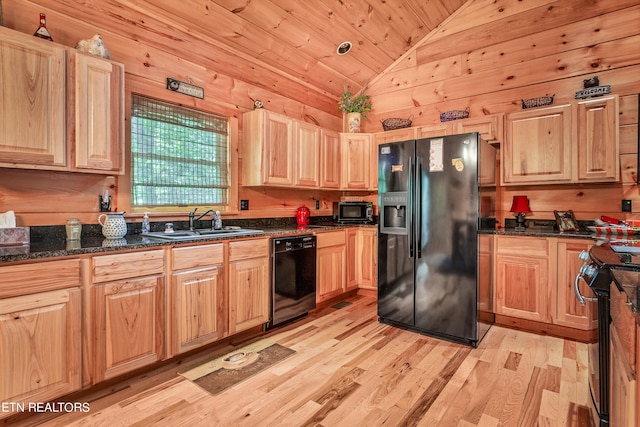 kitchen featuring wooden walls, light hardwood / wood-style floors, black appliances, and lofted ceiling