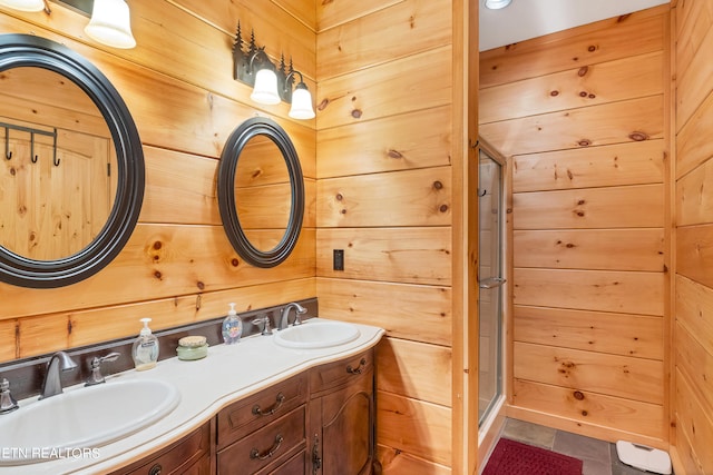 bathroom with double vanity, wood walls, tile floors, and a shower with shower door