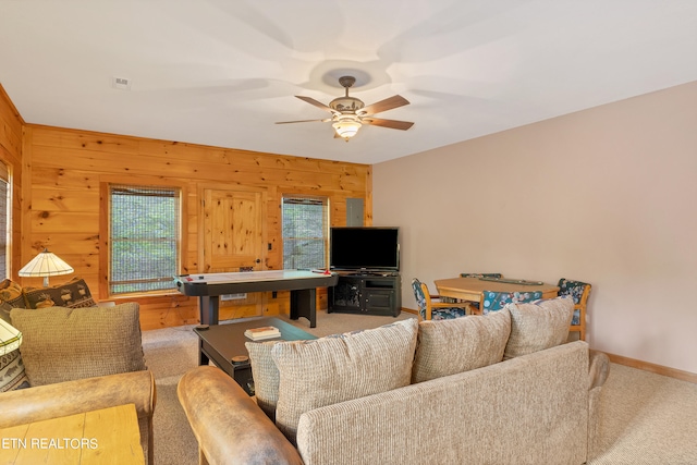 living room featuring ceiling fan and wooden walls