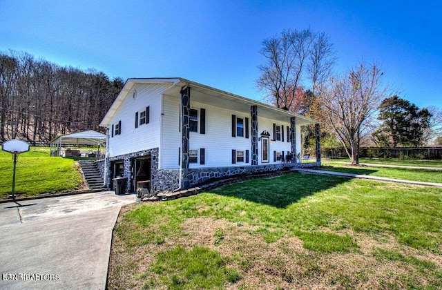 split foyer home featuring a carport and a front yard