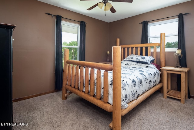 carpeted bedroom featuring multiple windows and ceiling fan