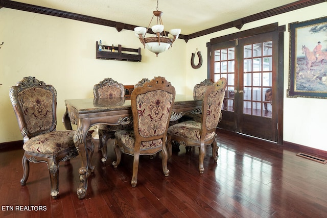 dining area with hardwood / wood-style flooring, crown molding, french doors, and a chandelier