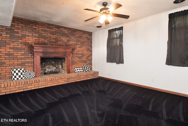 unfurnished living room featuring ceiling fan, carpet, a fireplace, a textured ceiling, and brick wall