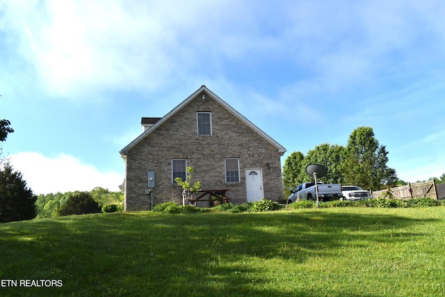 view of side of home with a yard