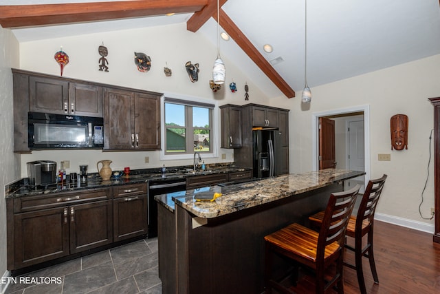 kitchen with a center island, pendant lighting, dark hardwood / wood-style flooring, black appliances, and dark stone countertops