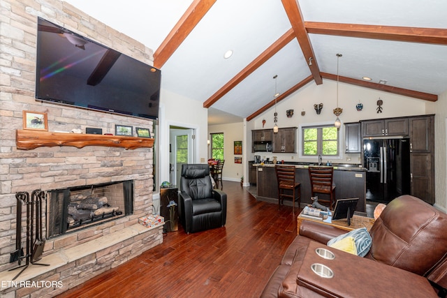 living room with wood-type flooring, high vaulted ceiling, a fireplace, beam ceiling, and sink