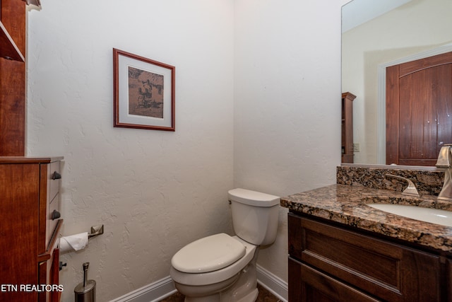 bathroom featuring vanity with extensive cabinet space and toilet