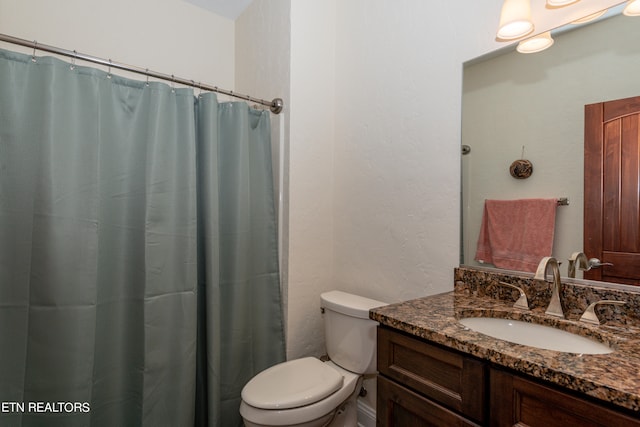 bathroom with vanity with extensive cabinet space and toilet