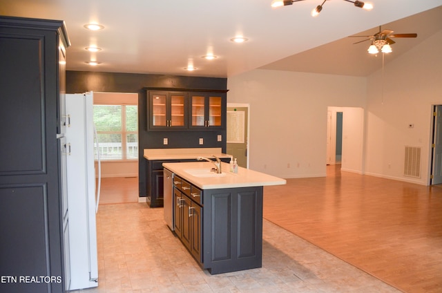 kitchen with white refrigerator, sink, ceiling fan, an island with sink, and light hardwood / wood-style floors