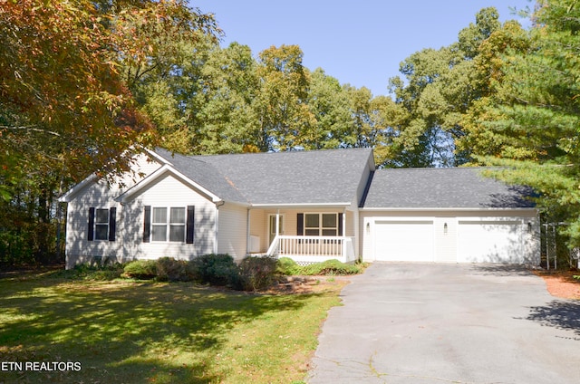 ranch-style home featuring covered porch, a garage, and a front lawn