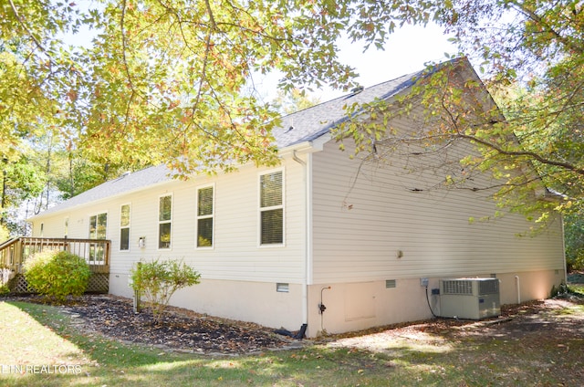 view of side of home featuring a wooden deck and central AC