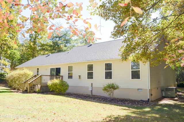 back of house featuring a yard, a wooden deck, and central AC