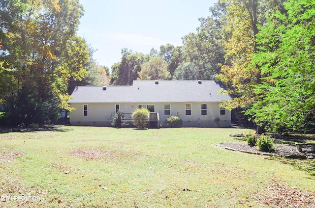 rear view of house featuring a yard